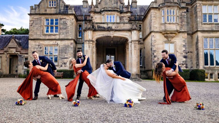 Wedding party dipping their partners in front of Muckross House, Killarney