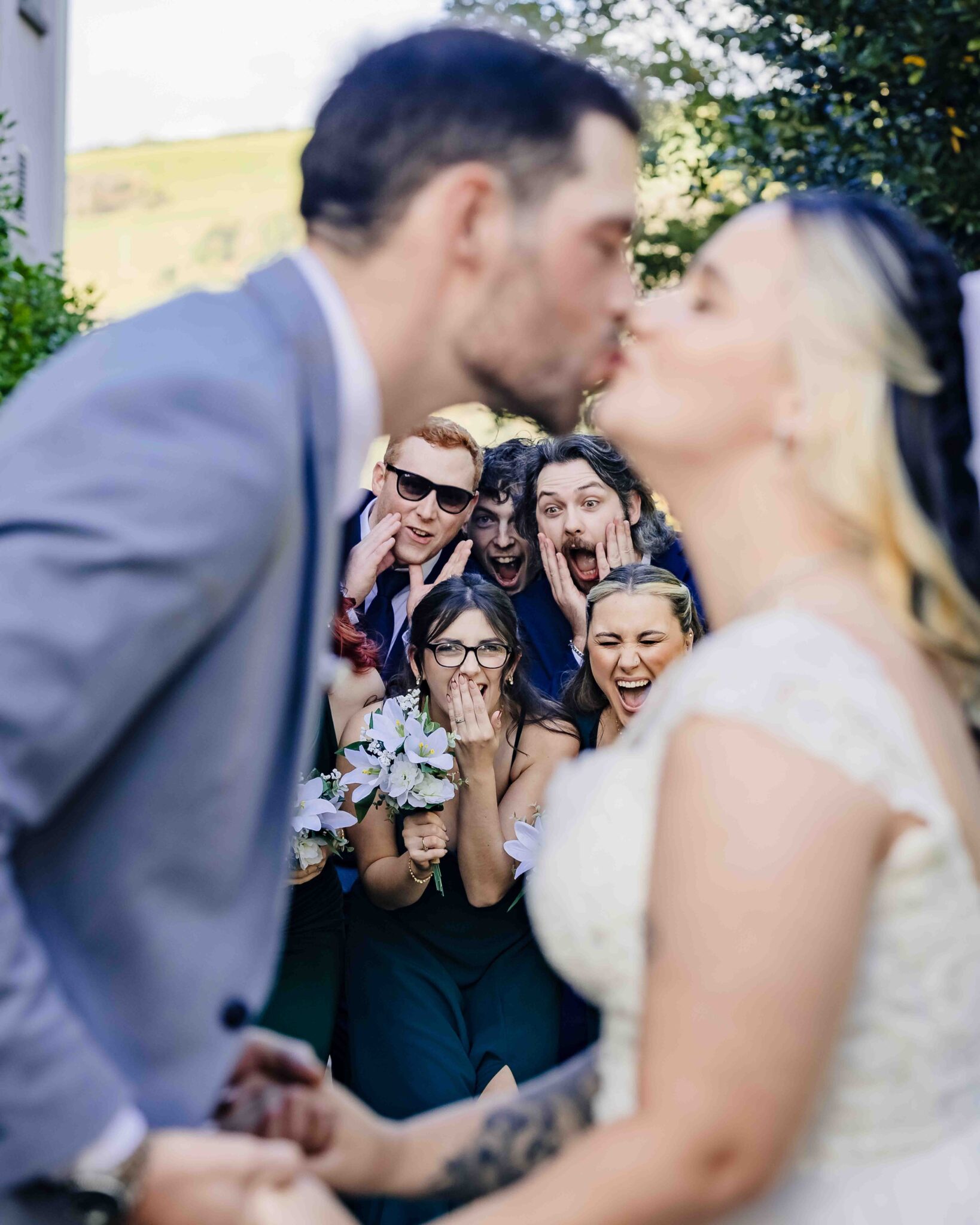 Shannon and Brandon kiss while their friends gasp and cheer behind them at the Talbot Hotel Cork wedding