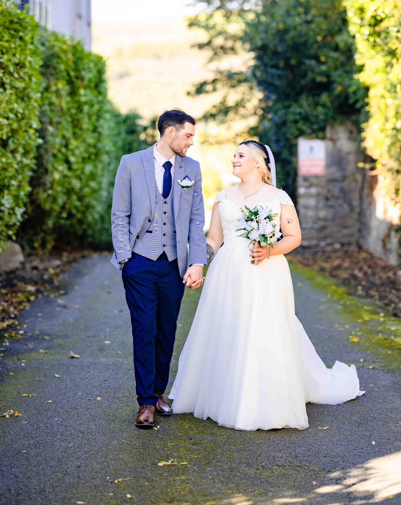 Shannon and Brandon walk hand in hand down the walkway at the Talbot Hotel Cork in autumn light, Cork wedding photographer