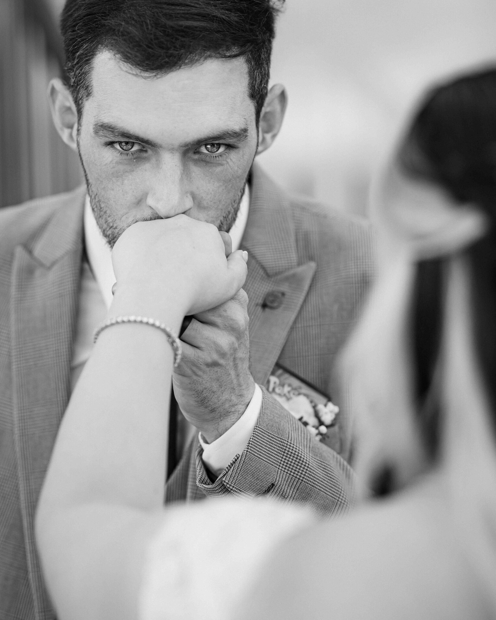 Black and white portrait of Brandon with his hand to his mouth and Shannon in the foreground, Talbot Hotel Cork wedding photographer