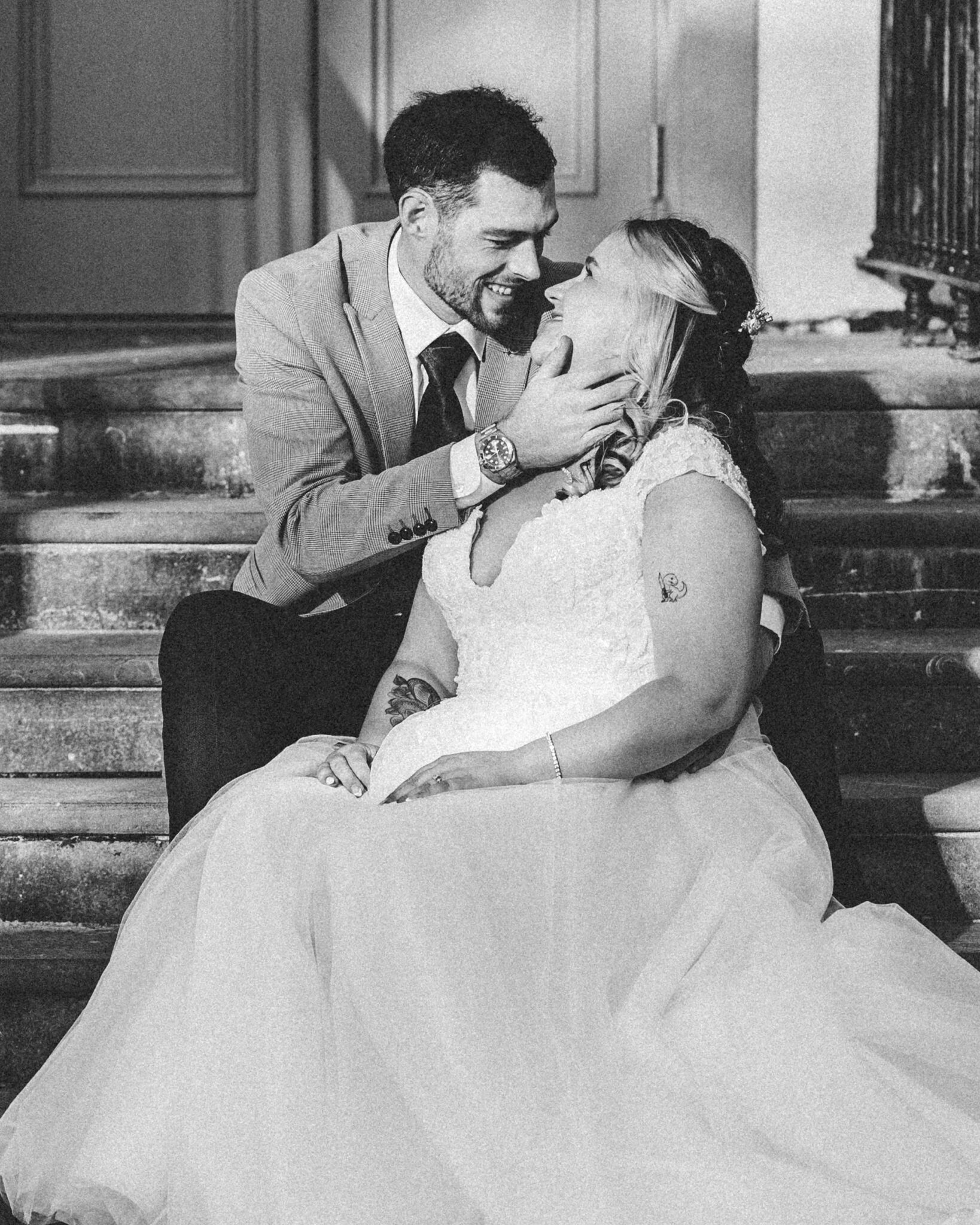 Black and white photo of Brandon cupping Shannon's face on the steps outside the Talbot Hotel Cork wedding
