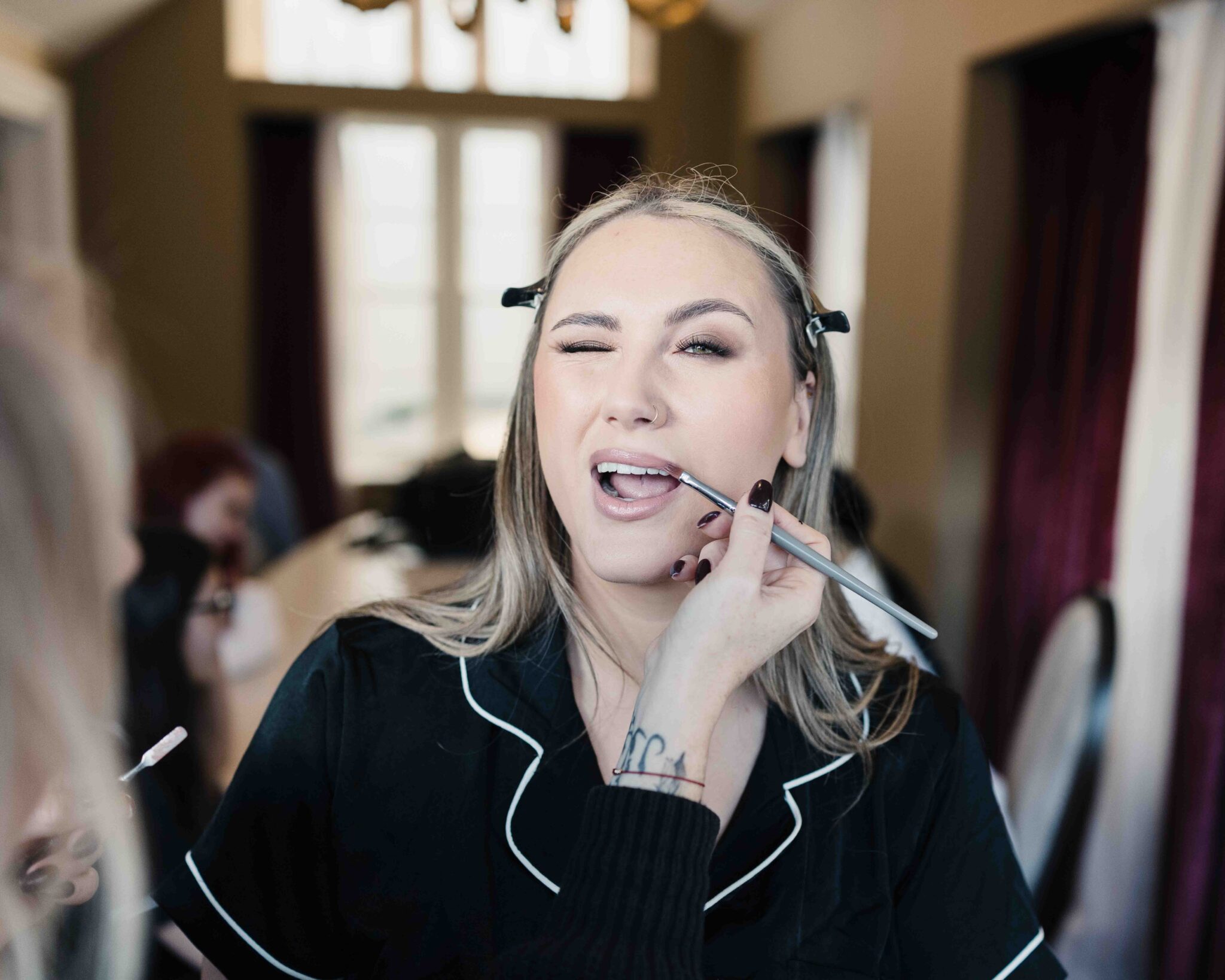 Bridesmaid winks while doing her make-up on the morning of the Talbot Hotel Cork wedding, relaxed wedding photographer Cork