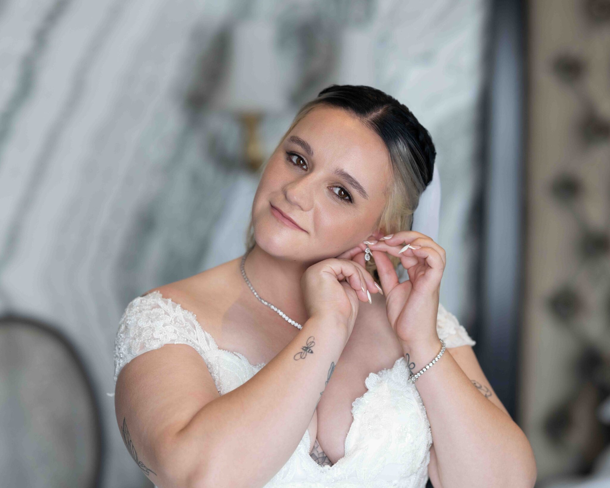 Shannon smiles while putting in her earring in her wedding dress at the Talbot Hotel Cork, Cork wedding photography