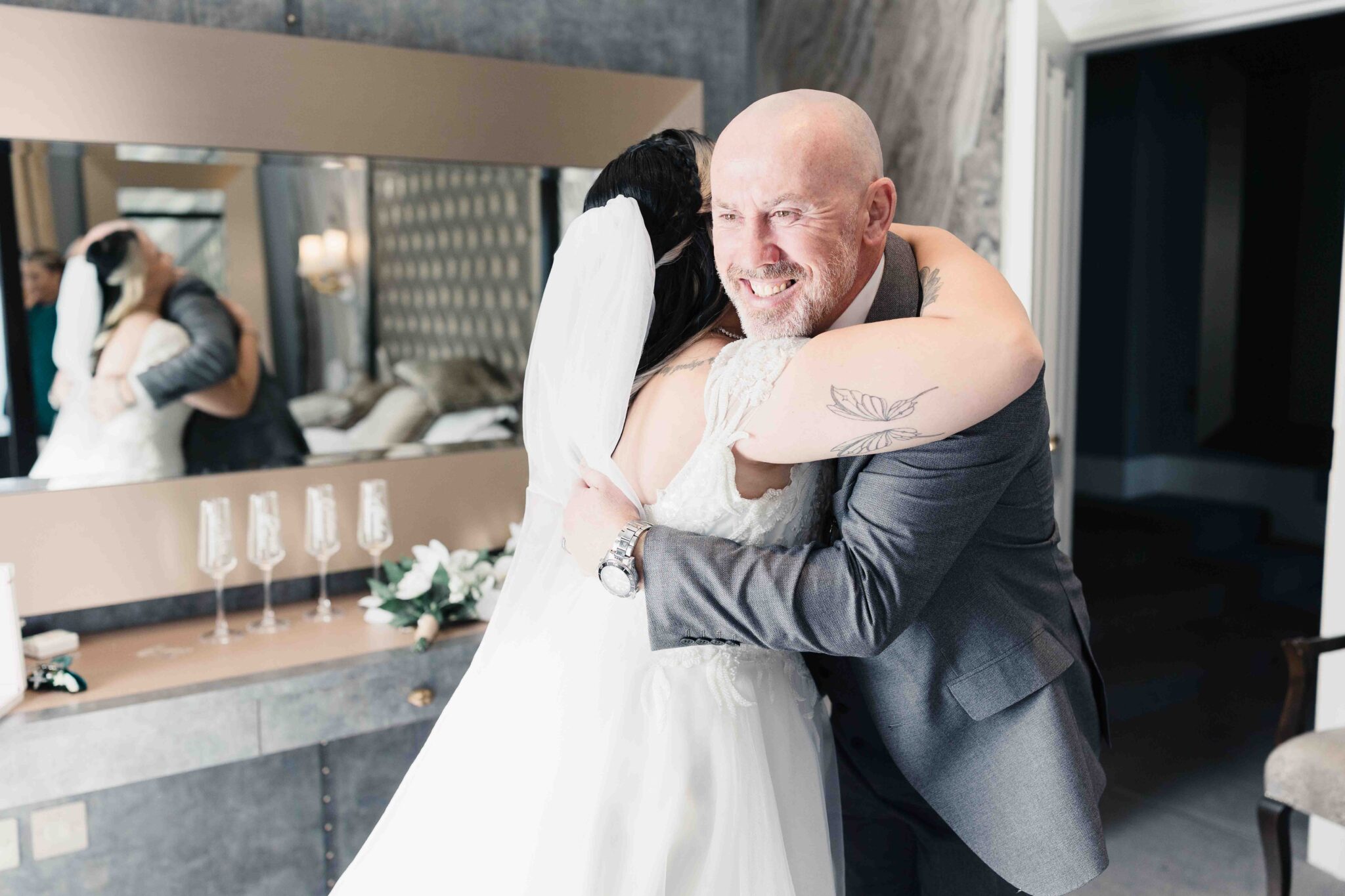 Shannon hugs a smiling man at the bedroom door at the Talbot Hotel Cork, Cork wedding photographer