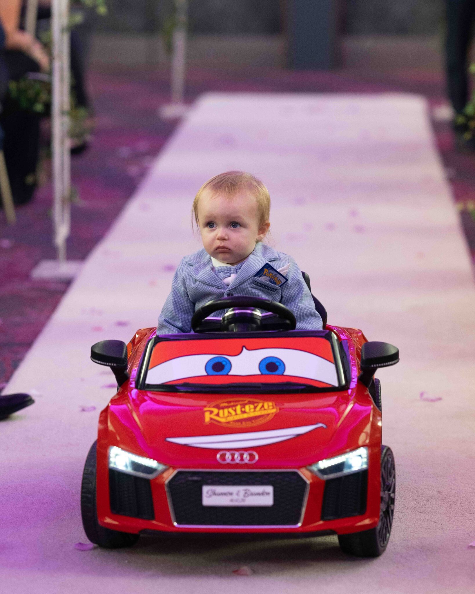 Little boy drives a red toy car down the aisle at the Talbot Hotel Cork wedding ceremony, Cork wedding photography