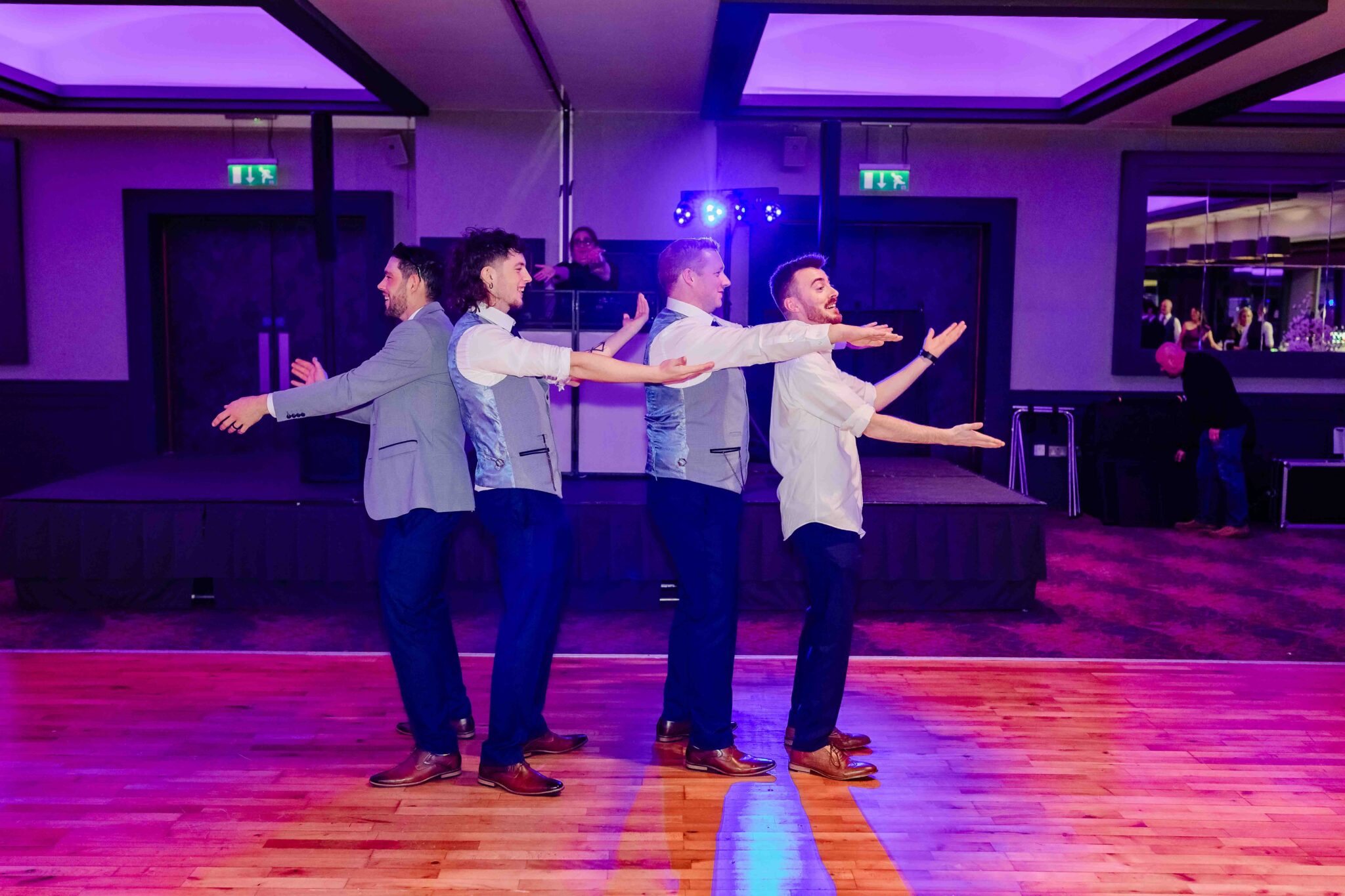 The groomsmen dance across the floor under purple lights at the Talbot Hotel Cork wedding reception