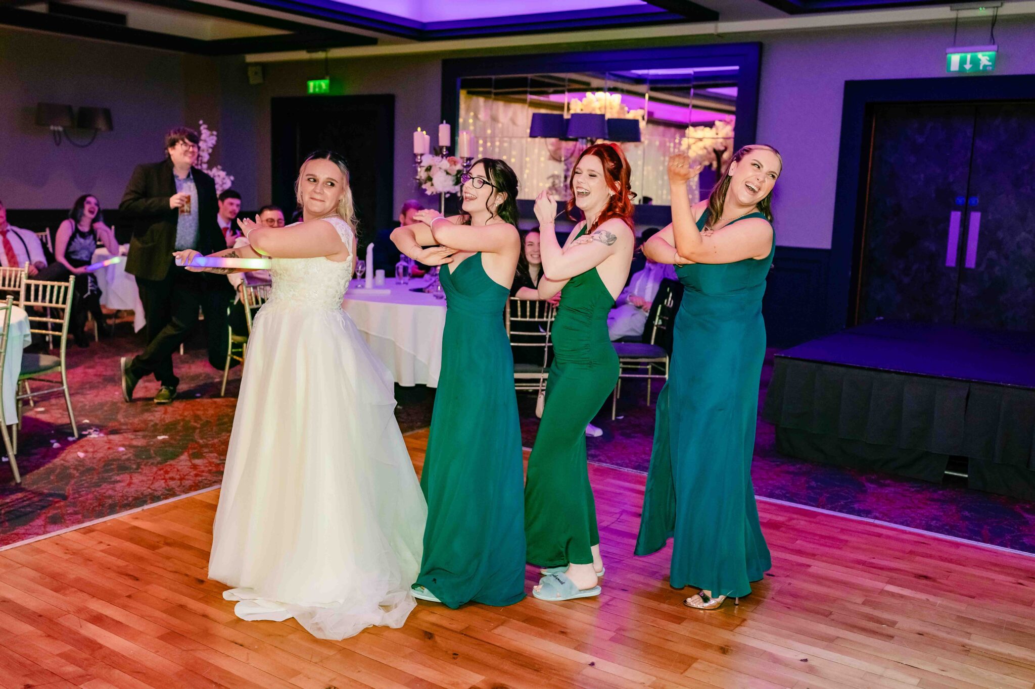 Shannon dances with her bridesmaids in green dresses under purple lights at the Talbot Hotel Cork wedding