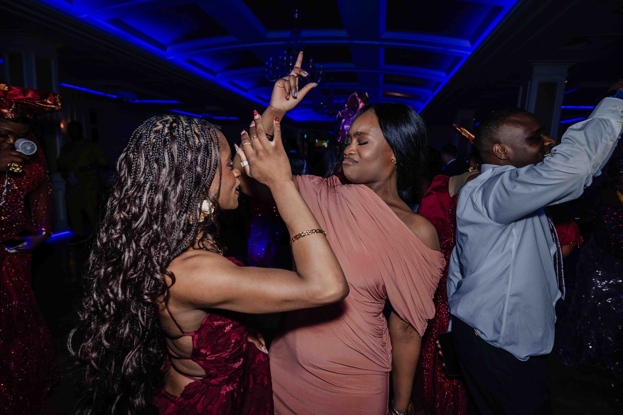 Two guests dance in the blue light of the dance floor at Vienna Woods Hotel wedding, Cork