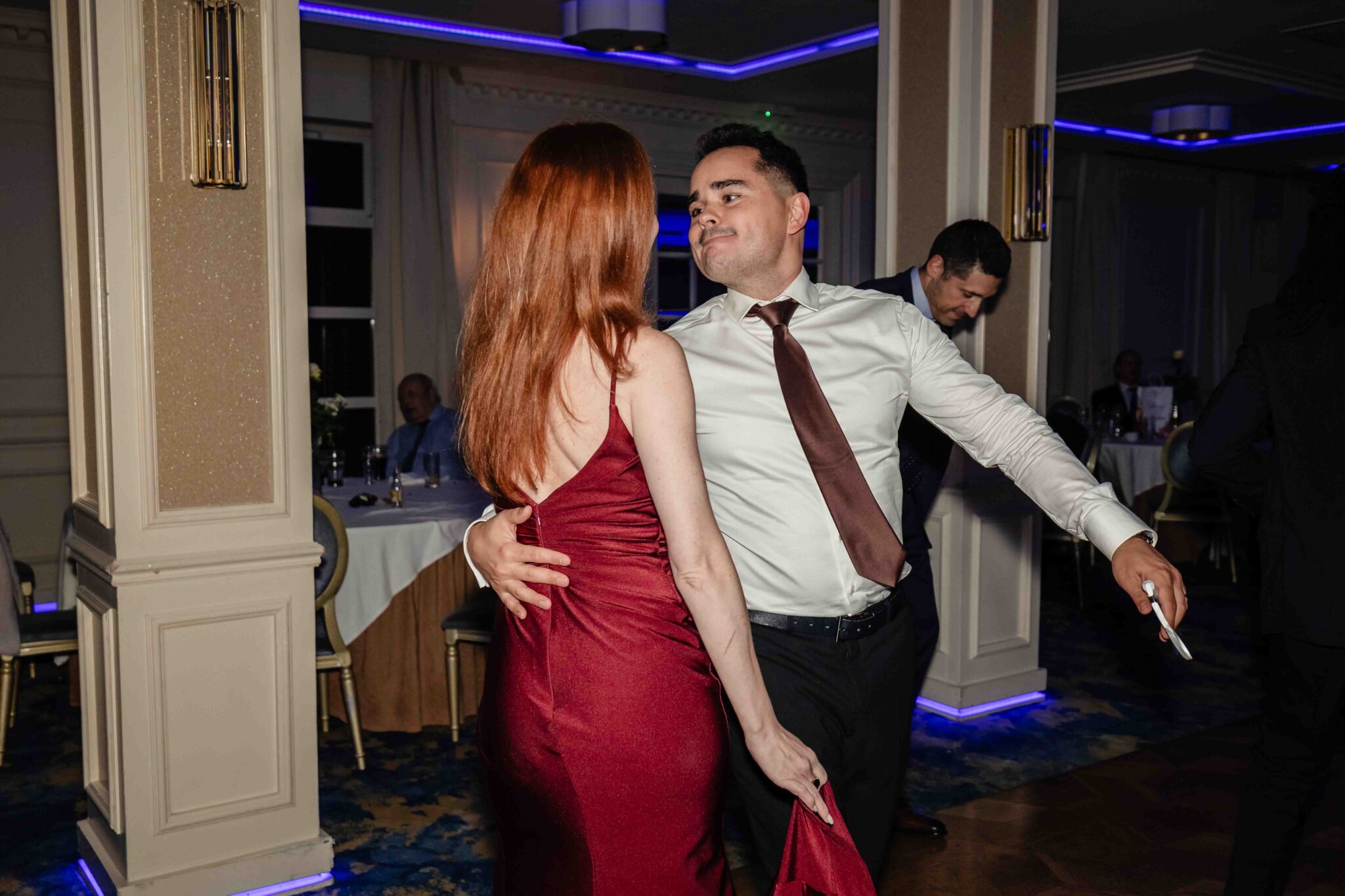 Guests dance together under blue uplighting at the Vienna Woods Hotel wedding reception, Cork