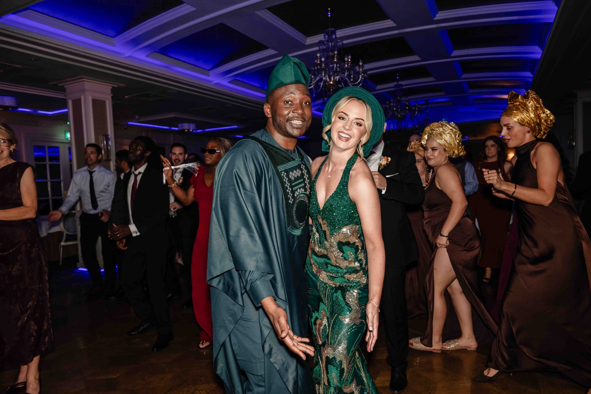 Bride and groom in matching green African outfits on the dance floor at Vienna Woods Hotel, Irish Nigerian wedding Cork