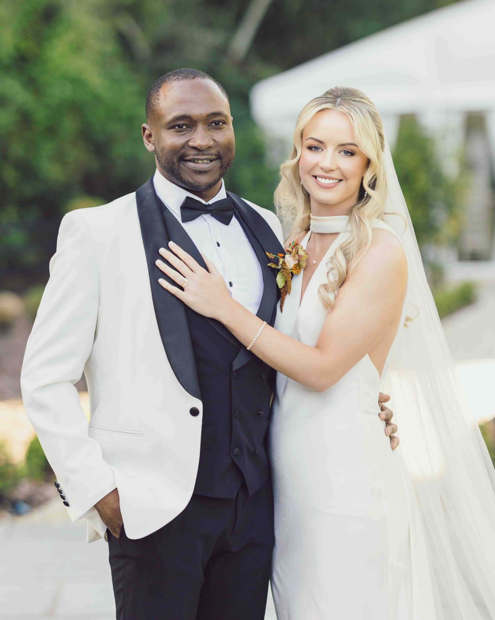 Groom in a white dinner jacket embraces Stacey in her satin wedding dress at Vienna Woods Hotel, Cork wedding photographer