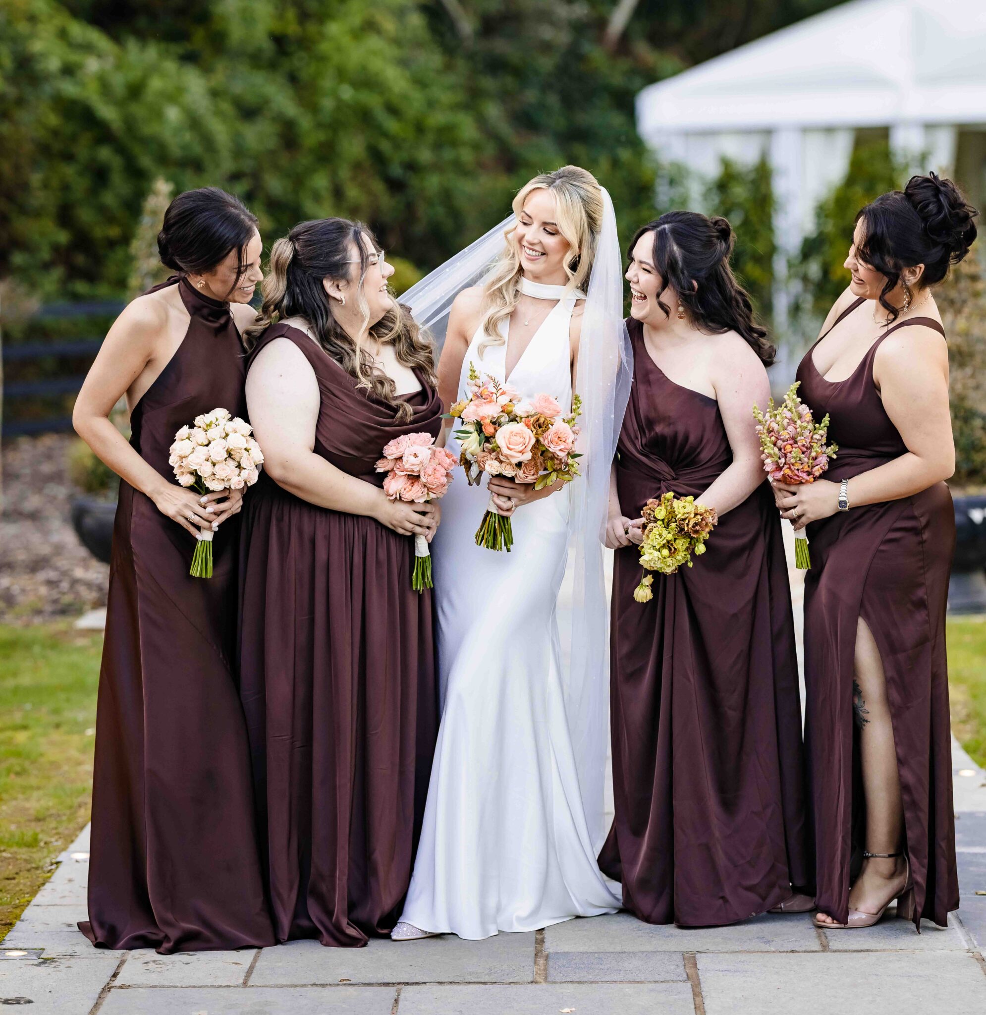 Bride with her bridesmaids in chocolate brown satin holding peach and orange bouquets at Vienna Woods Hotel, Cork