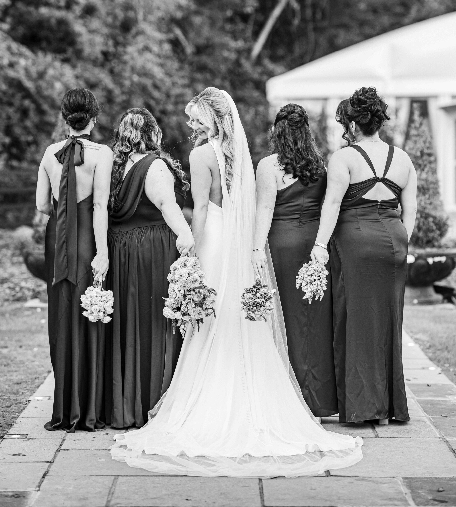 Black and white photo of the bride and her bridesmaids from behind on the stone path, Vienna Woods Hotel, Cork wedding