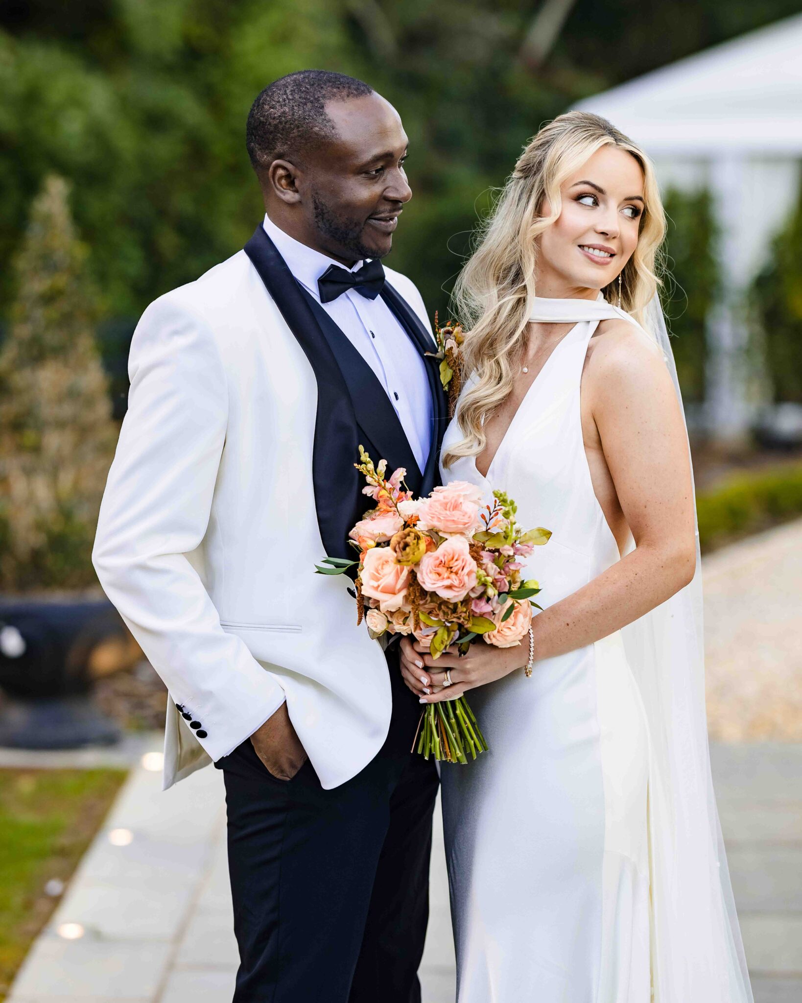 Bride and groom pose together, white dinner jacket and satin wedding dress, at Vienna Woods Hotel, Cork