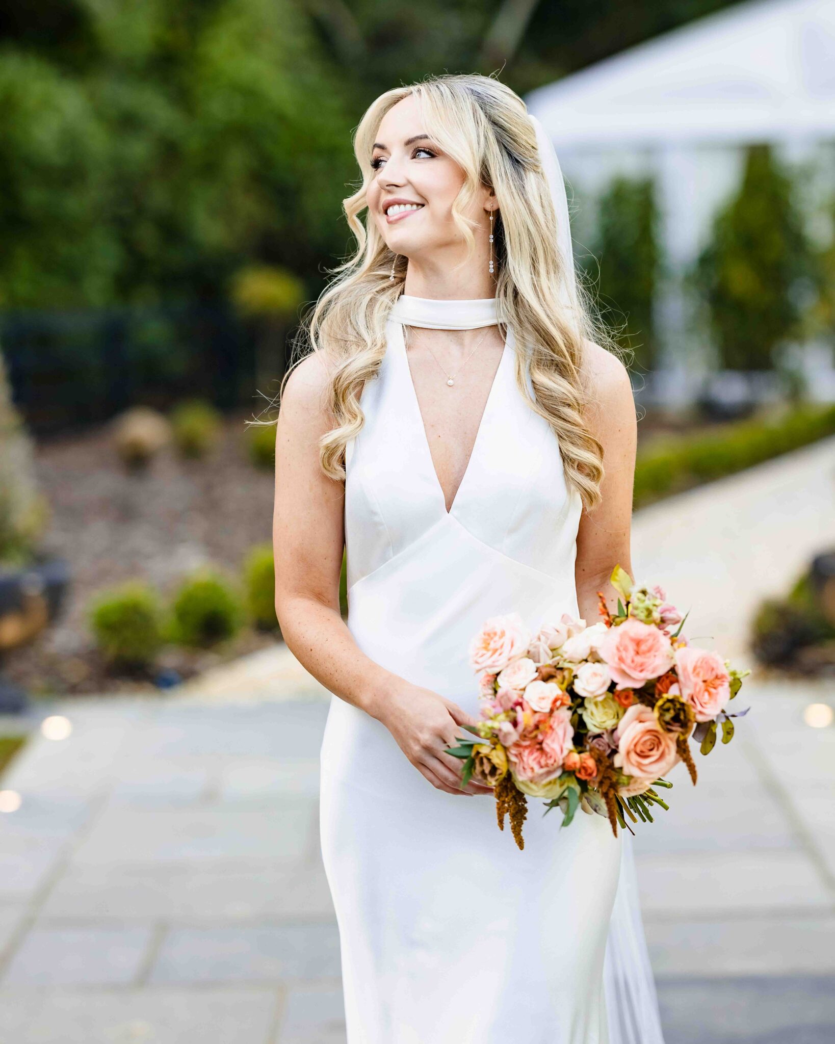 Stacey laughs looking away in a white satin wedding dress with scarf neckline and peach bouquet, Cork bridal photography