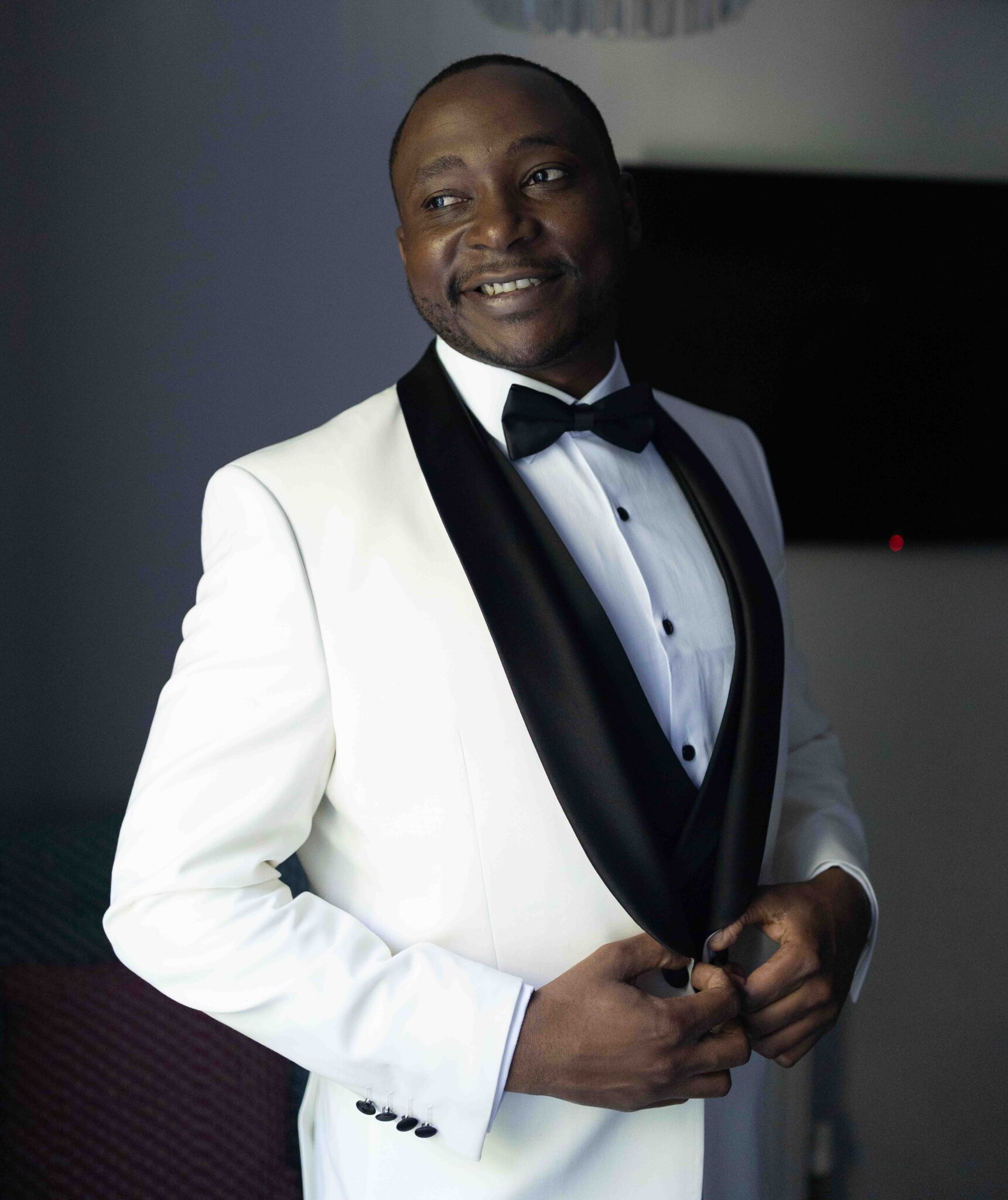 Groom Mahan in a white dinner jacket with black lapels, groom portrait at Vienna Woods Hotel, Cork wedding