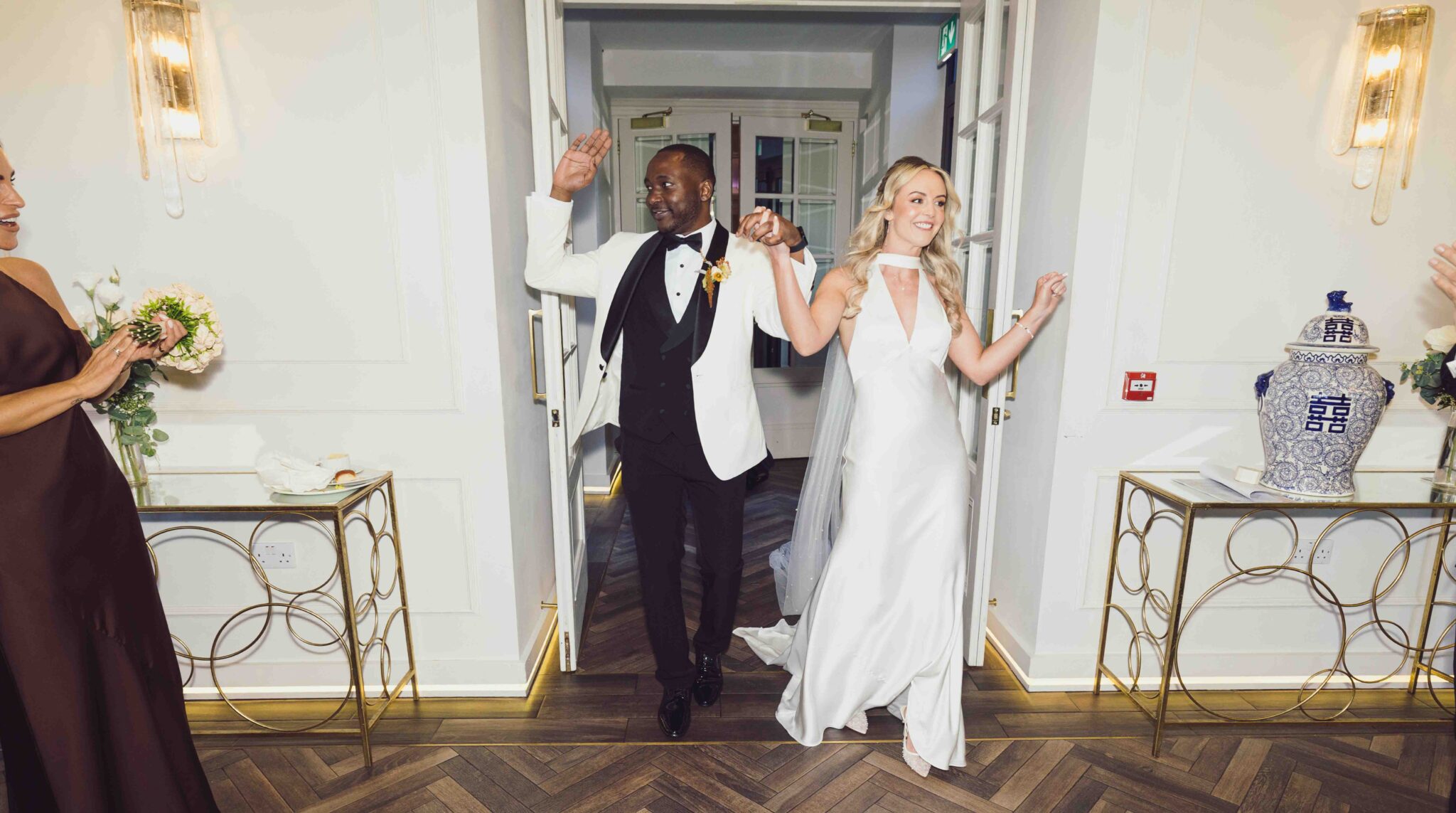 Bride and groom dance through the doorway at Vienna Woods Hotel as they arrive to celebrate, Cork wedding photography