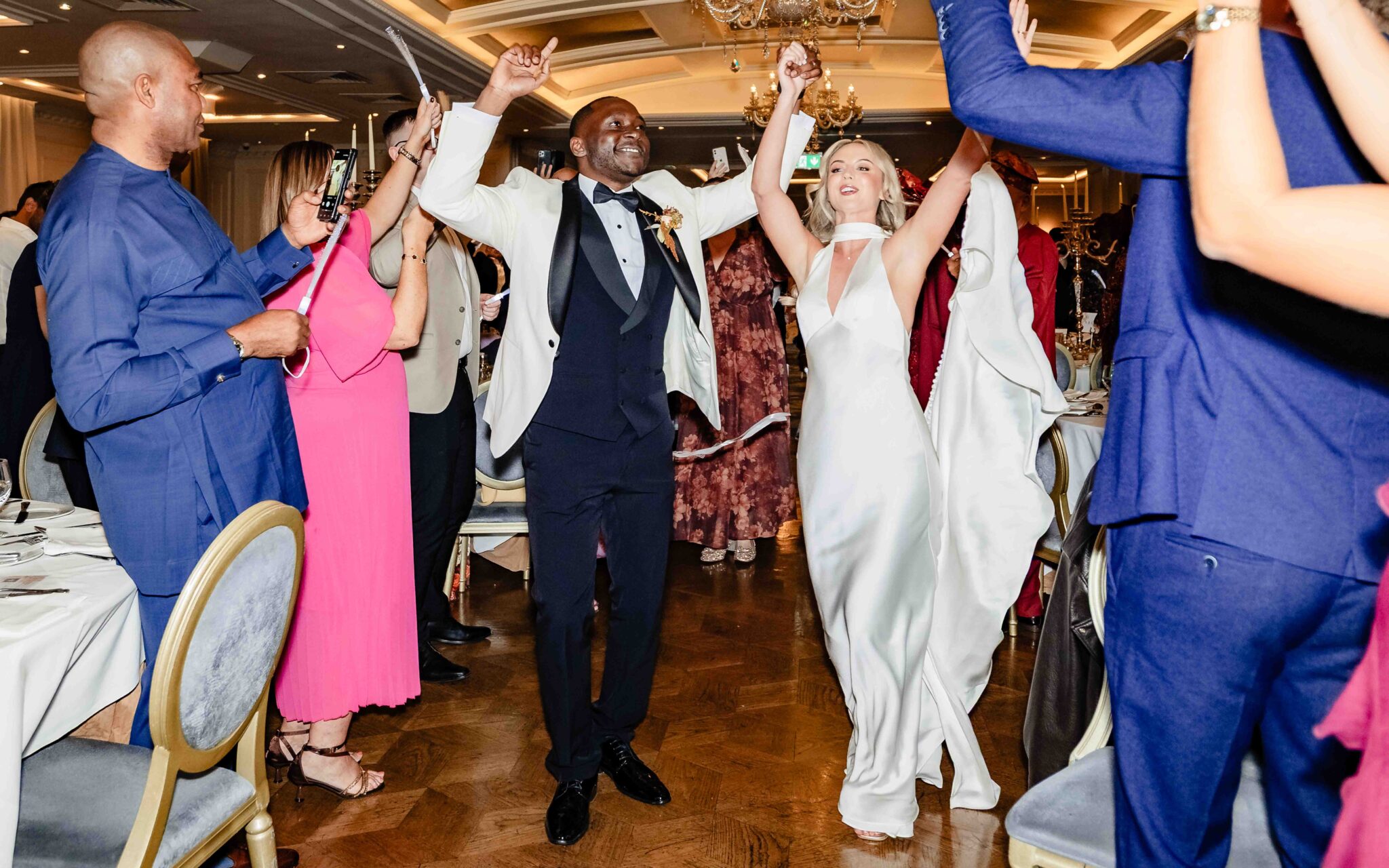 Bride and groom dance into the ballroom at Vienna Woods Hotel with guests on their feet, Cork wedding photographer