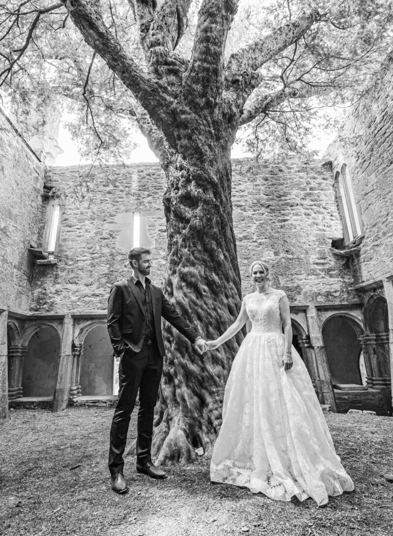 Paul smiling as he looks at Holly under the trees – JOD'Photography