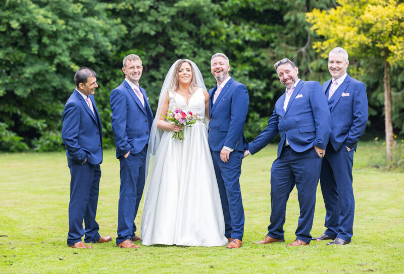 Bride walking down red carpet with guard of honour – JOD Photography