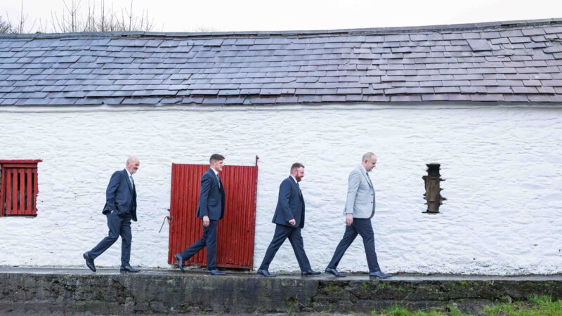 Groom laughing with groomsmen during morning prep at home — JOD Photography
