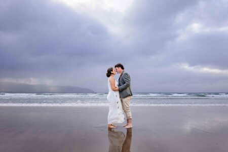 Aíne and Ciarán kissing beside the Atlantic Ocean on their wedding day